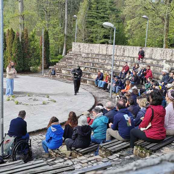 Een groep mensen luistert in een pantheon buiten setting naar een spreker van de Oogst van Overmorgen tijdens de European Learning Summit.