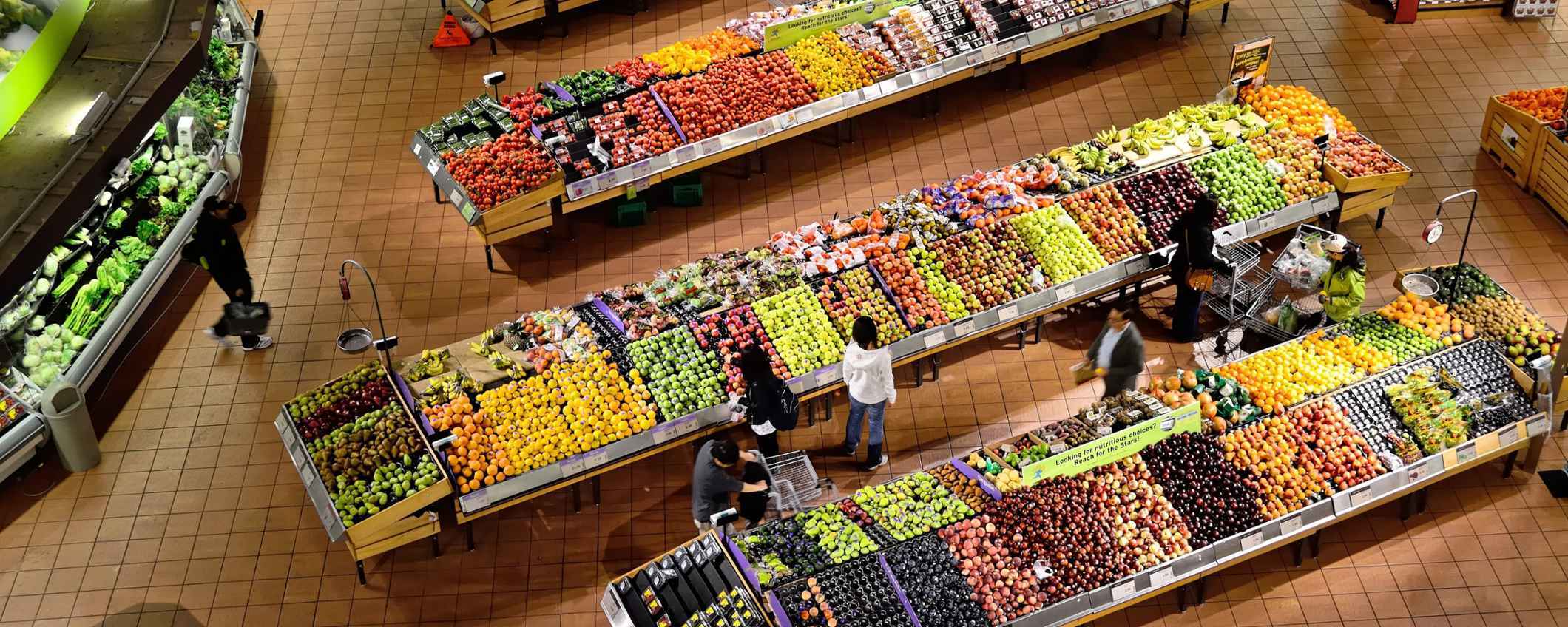 De groenteafdeling van een grote supermarkt van boven genomen.