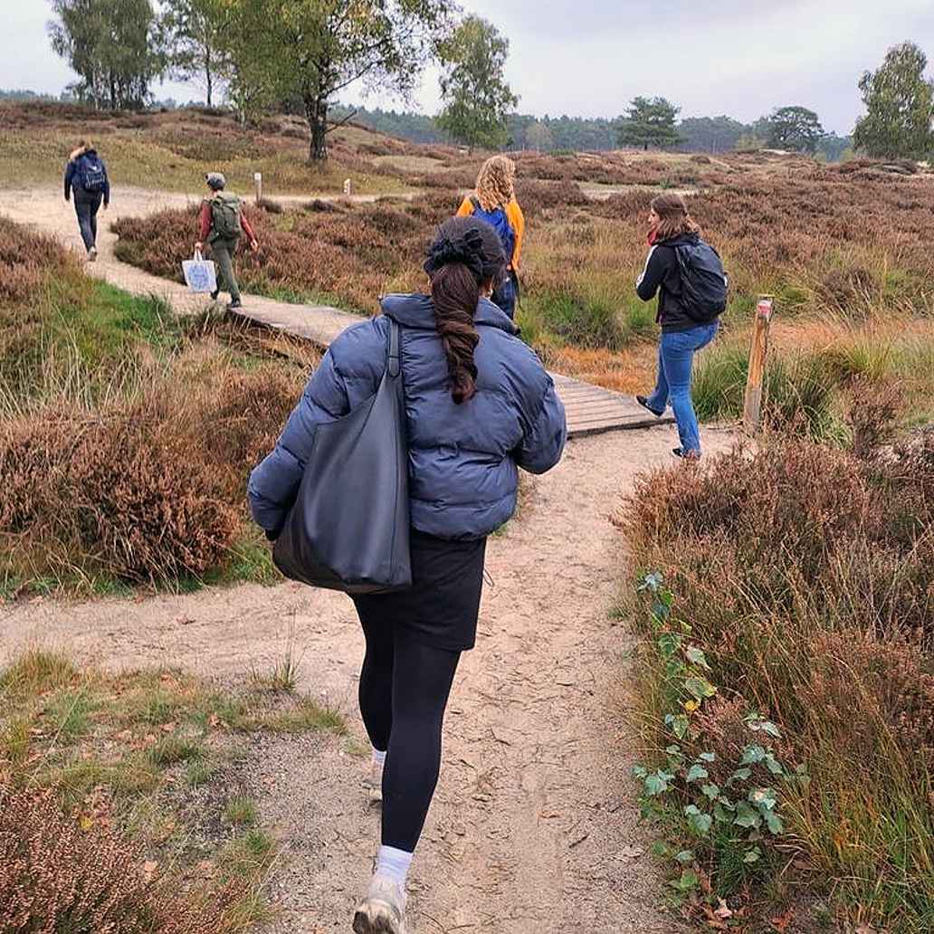 Vijf studenten lopen door een buitengebied als onderdeel van de minor OnderwijsBuiten.